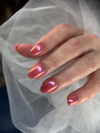 Close-up of a hand with pink nail polish against a light fabric background