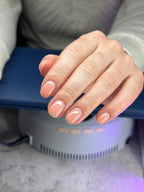Hand with pink nail polish on manicure master table