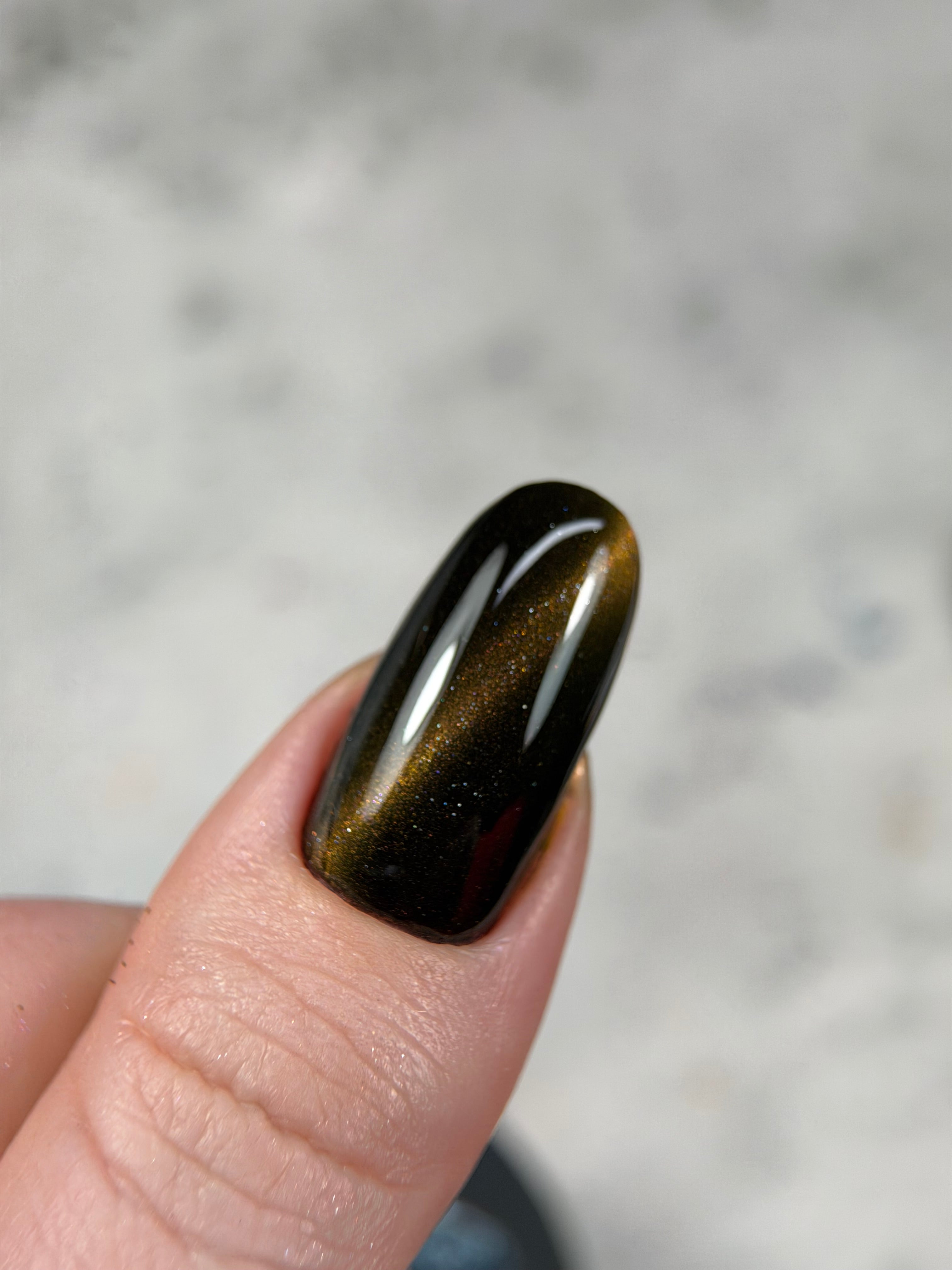 Person holding a polished obsidian stone against a blurred background
