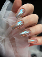 Close-up of a hand with metallic nail polish on a soft fabric background