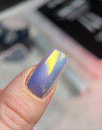 Nail with purple and yellow design on a blurred background