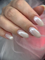 Close-up of a hand with clear nail polish against a soft, blurred background