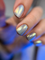 Close-up of a hand with silver glittery nail polish on a blurred background