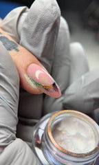 Close-up of a hand with a textured nail holding a small container with a rusty lid.