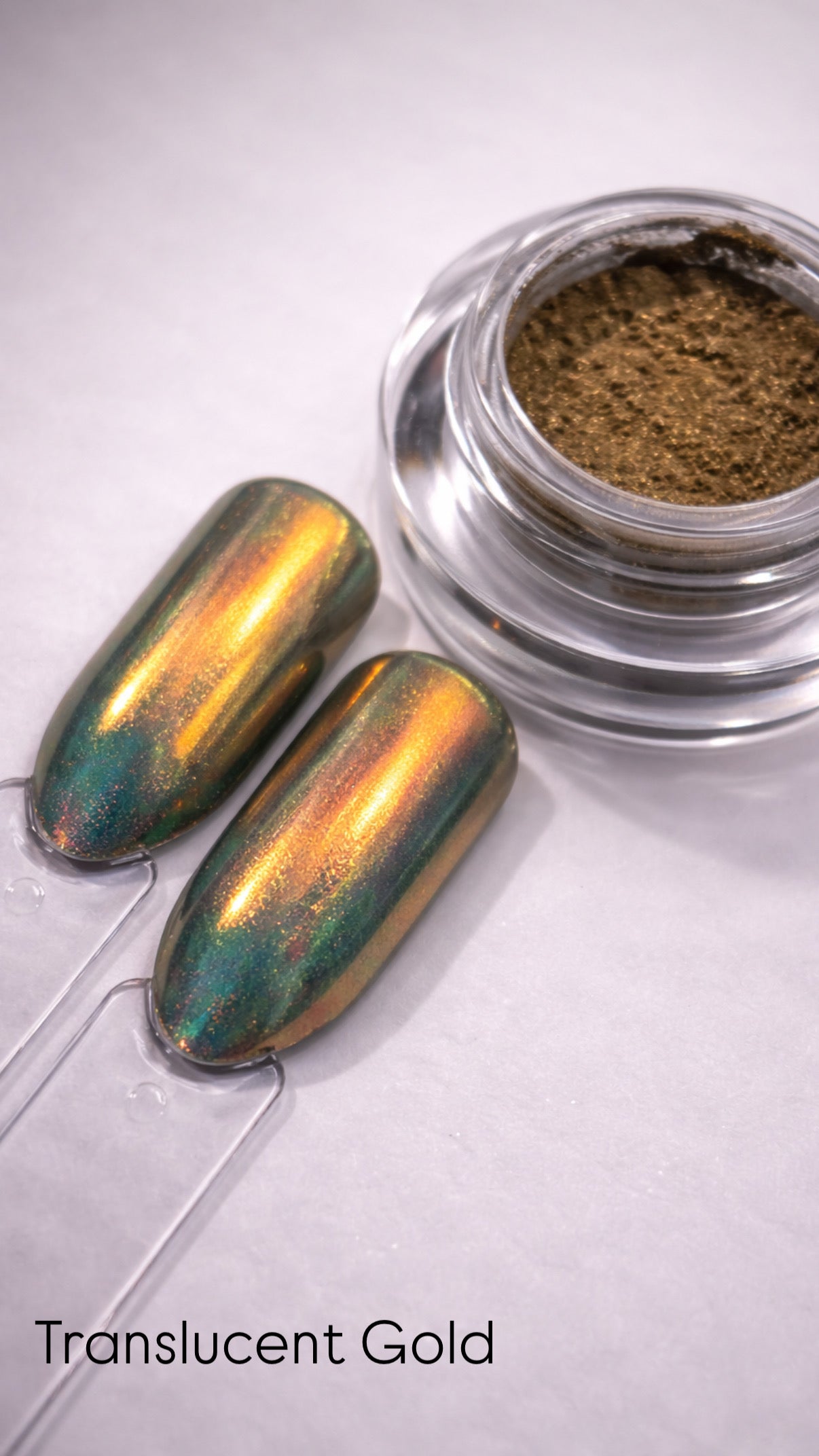 Translucent gold nail polish with a small container of brown powder on a white background