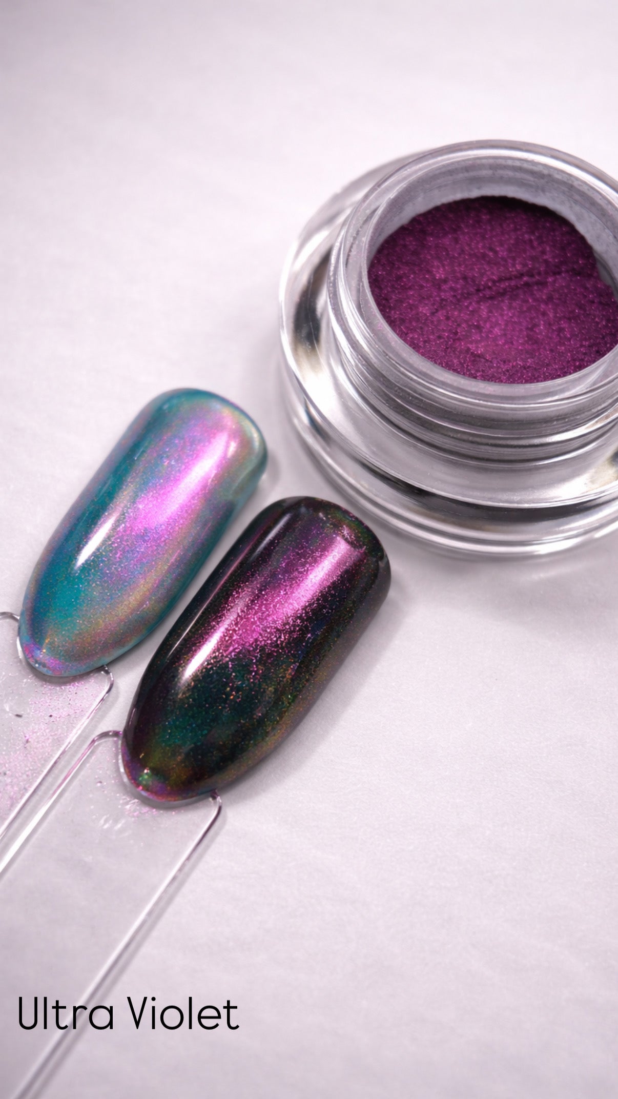 Chrome nail polish with a purple hue on a white background