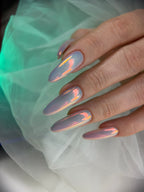 Close-up of a hand with gradient nail art on a light fabric background