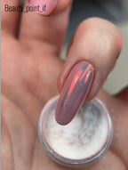 Nail with multicolored glittery polish and a container of nail powder.