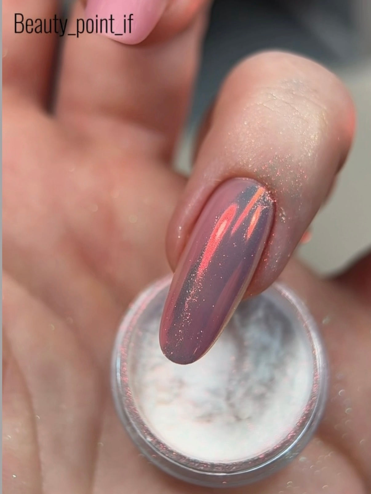 Nail with multicolored glittery polish and a container of nail powder.