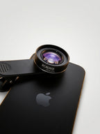Phone with a Foksha phone lens attachment on a white background
