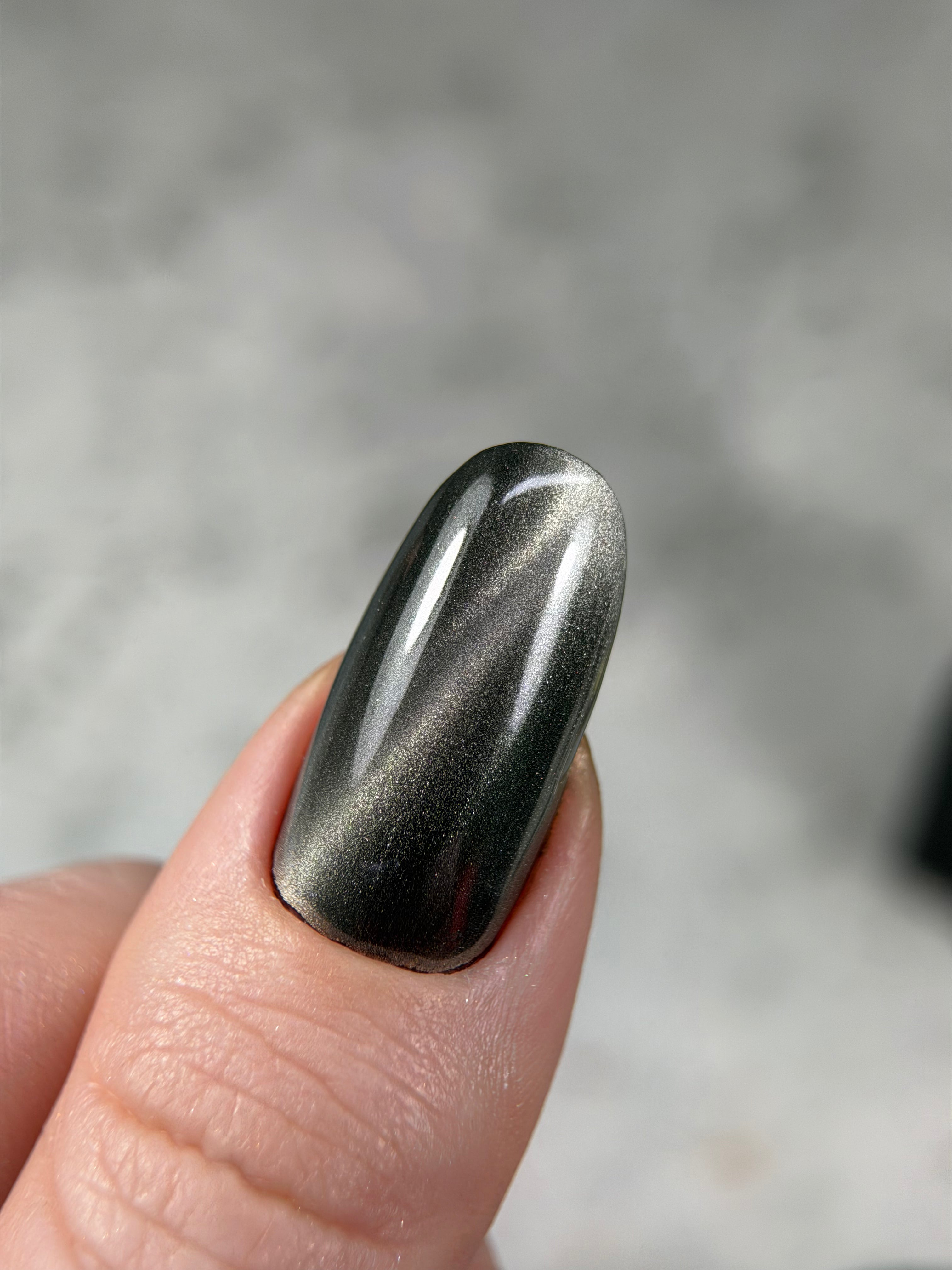 Metallic nail polish on a finger with a blurred background